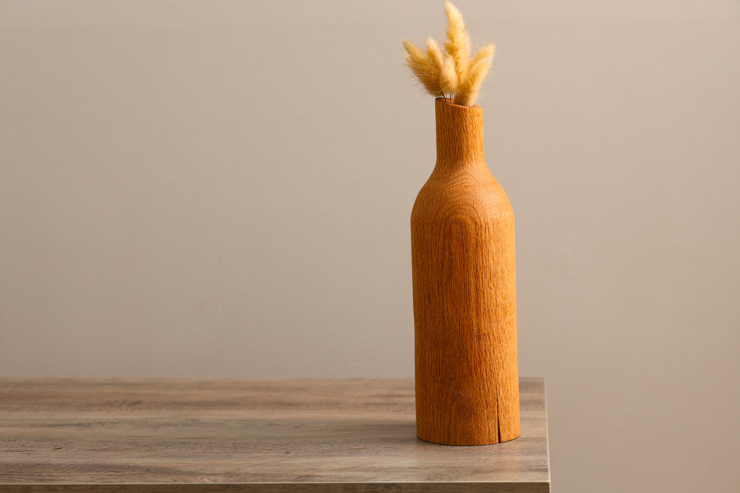Wood turned oak dry floral vase with bottle neck shape.