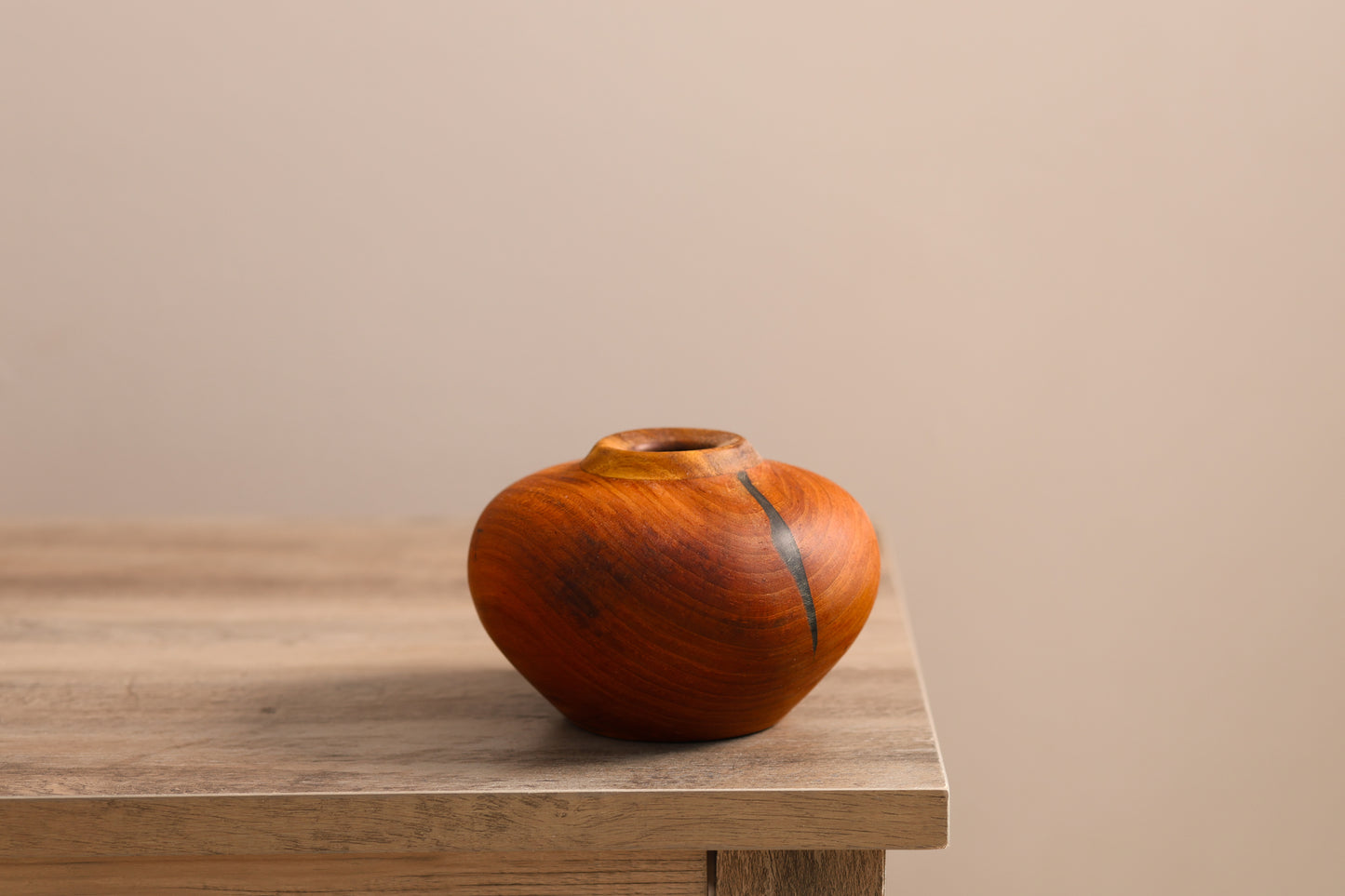 Wood turned cherry hollow form with a ring of walnut wood on the top. A naturally formed crack is filled in with black epoxy putty.
