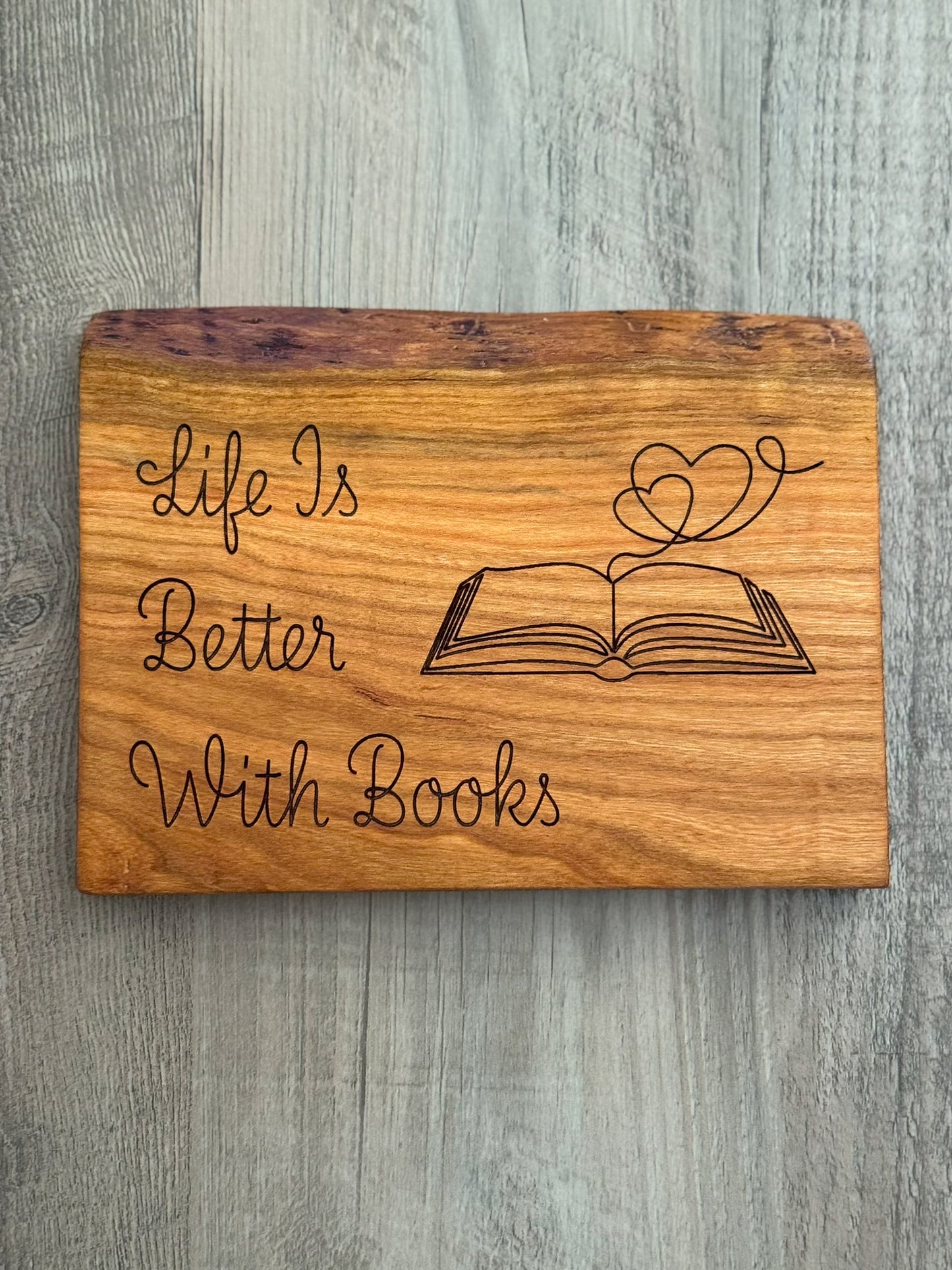 Cherry wood sign with laser engraved quote "Life Is Better With Books". With a laser engraved image of an open book with hearts coming out of it.