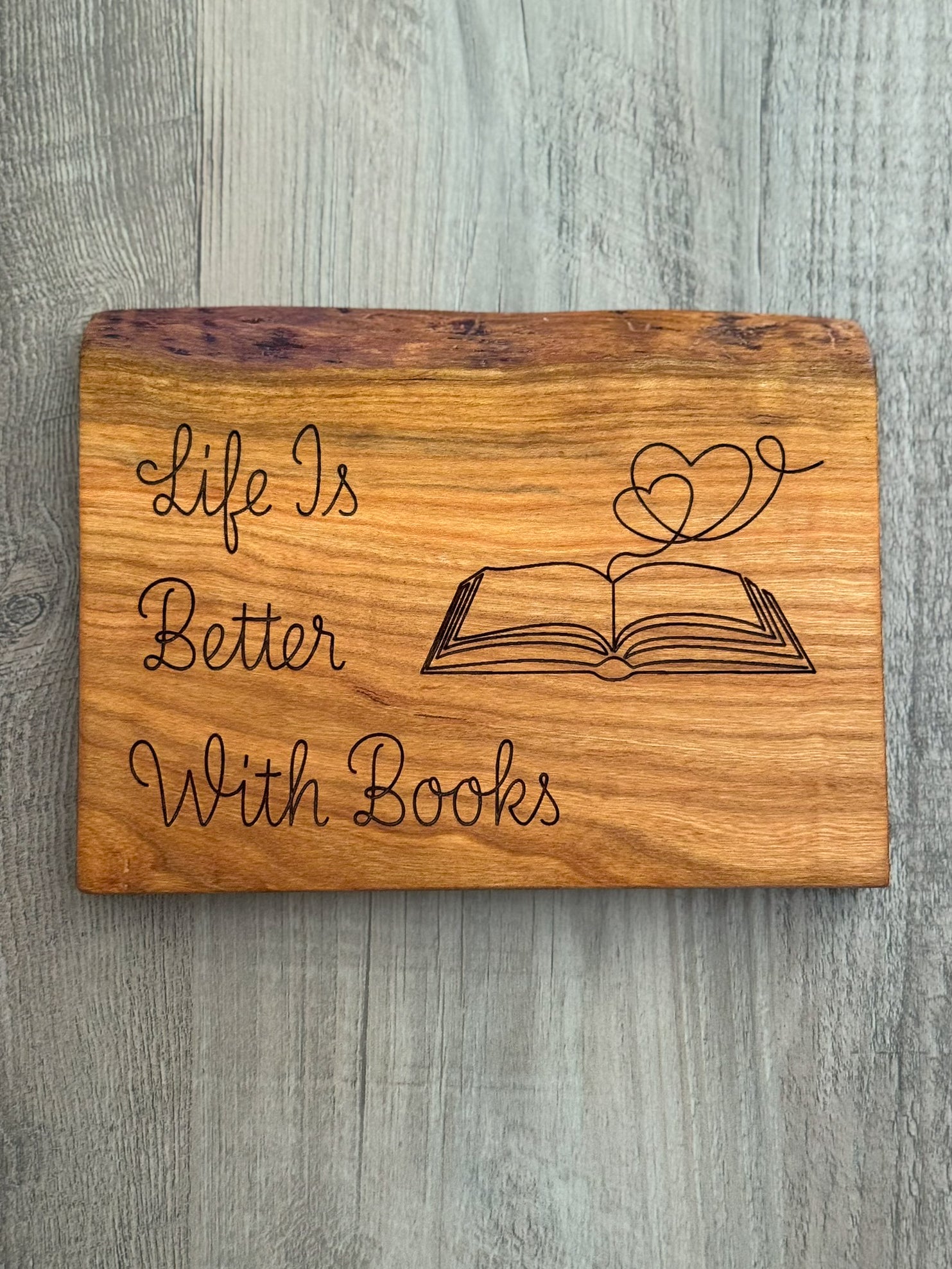 Cherry wood sign with laser engraved quote "Life Is Better With Books". With a laser engraved image of an open book with hearts coming out of it.