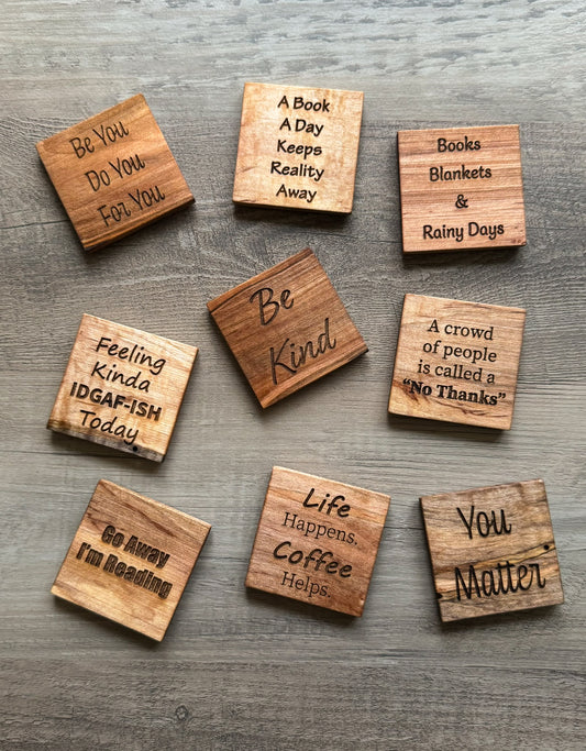 Wooden magnets with motivational phrases on a wooden surface